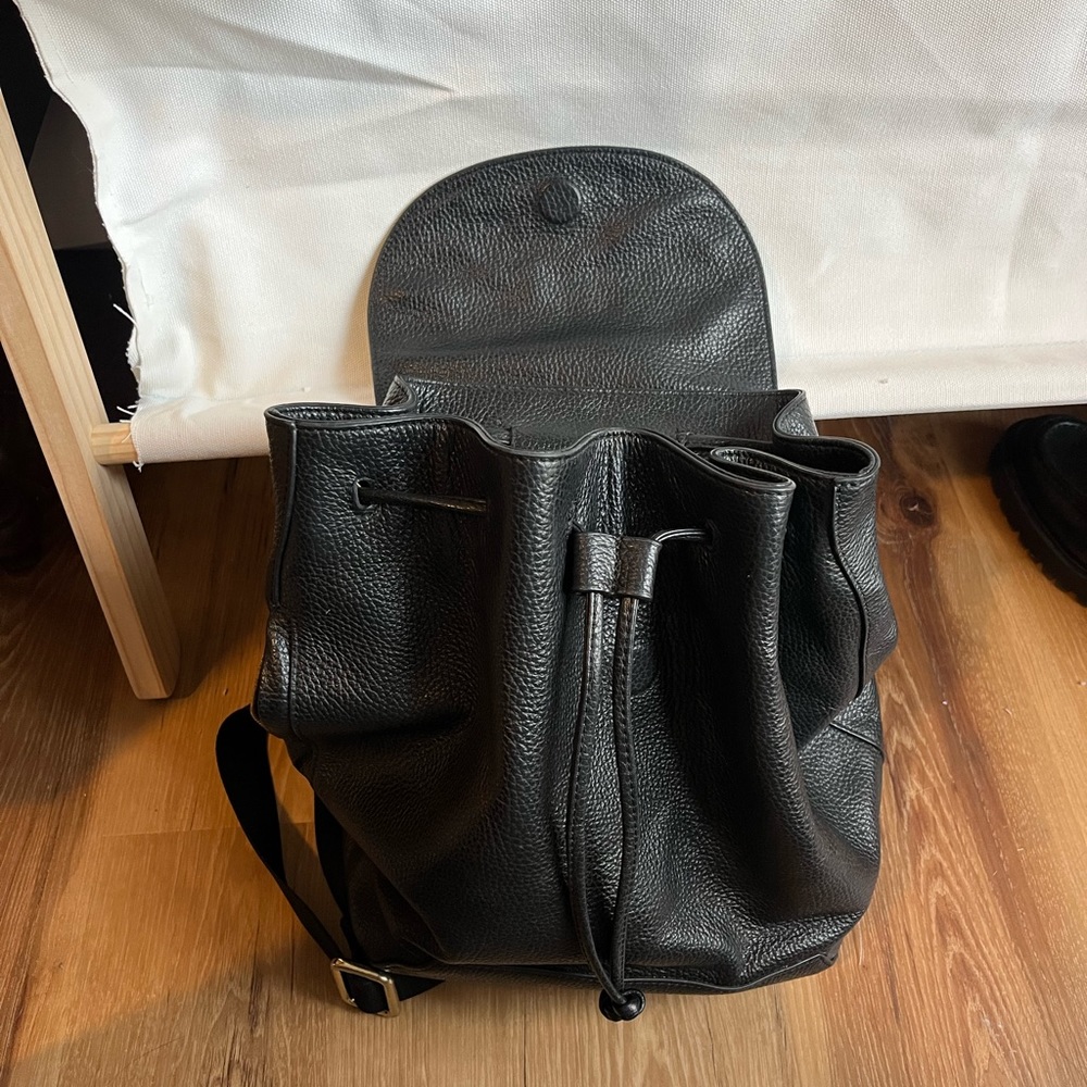 Genuine pebbled leather backpack with drawstring and handle.